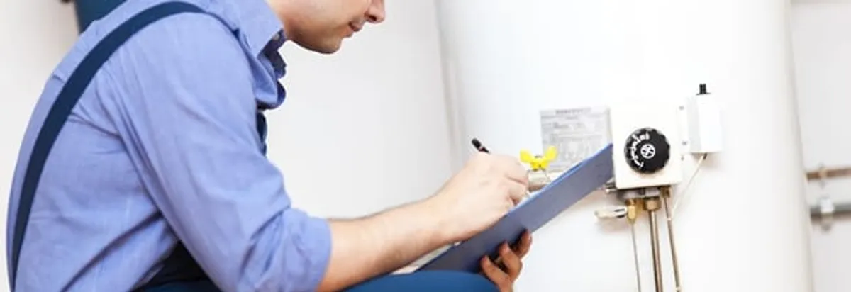 Water heater repair technician inspecting the unit and recording service notes in Chattanooga, TN